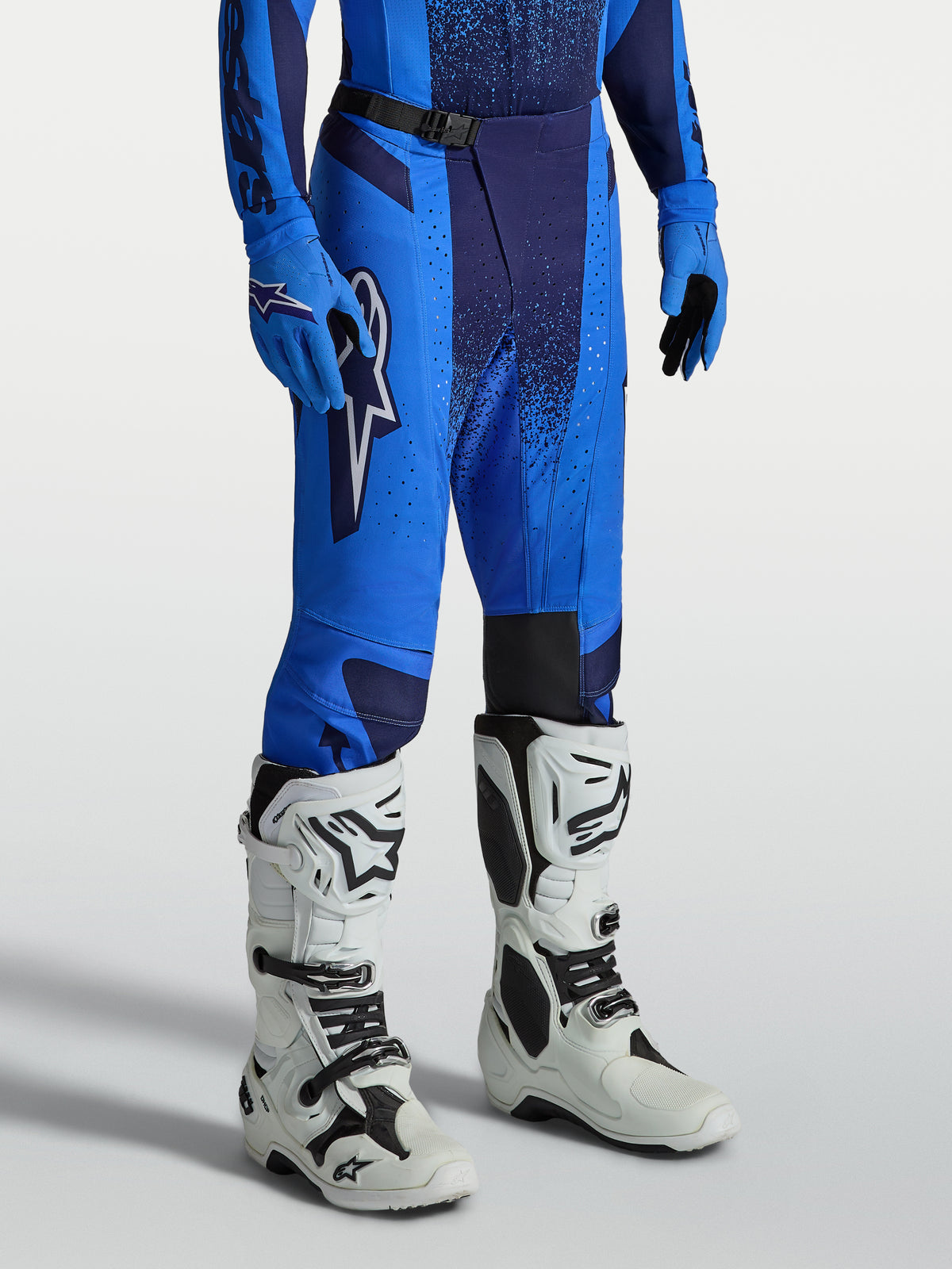 Alpinestars Techstar Swan broek, blauwe heren motorcrossbroek met 600D polystof-constructie en witte motorcrosslaarzen.