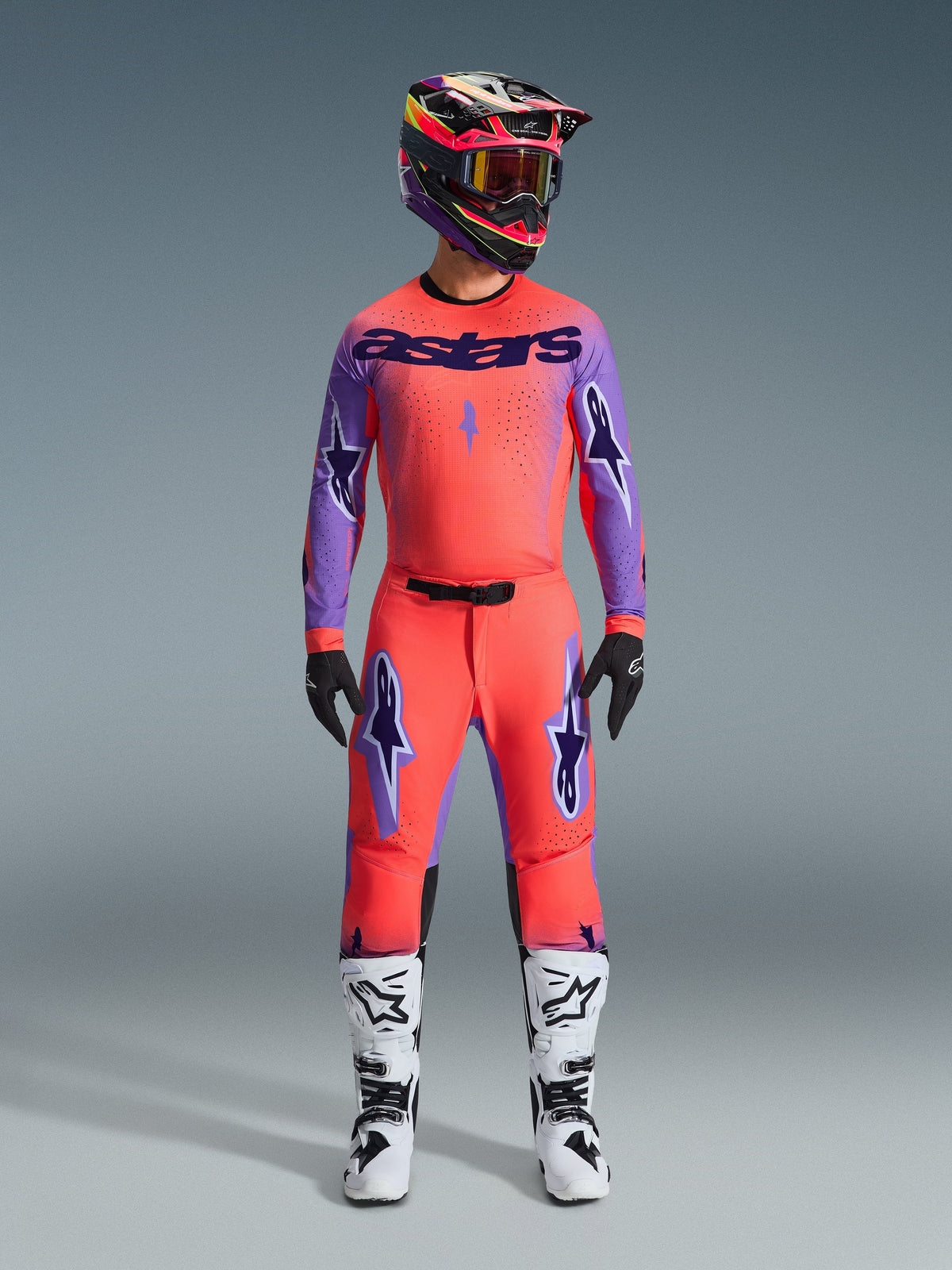 Alpinestars 2026 Supertech Scenz Pants, Motocross Pants, Hot Coral and Purple, worn as a complete gear set with matching jersey and helmet, white and black boots, featuring purple logos and athletic racing fit.