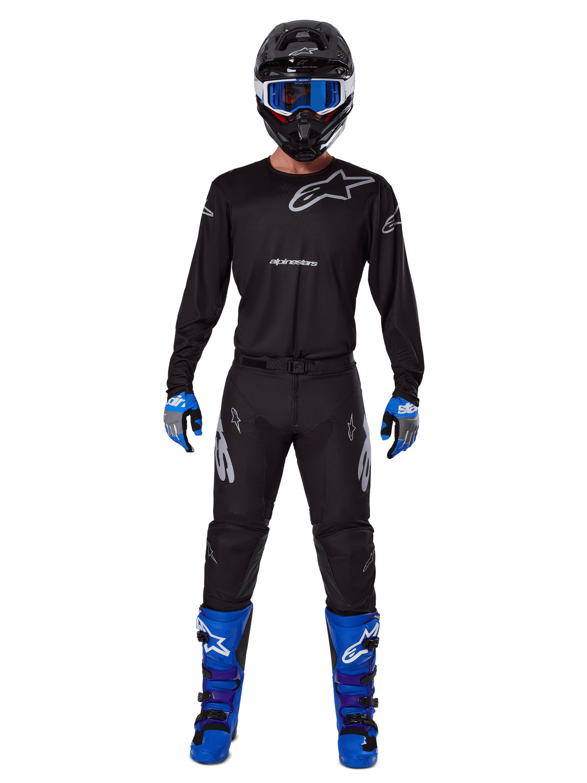 Alpinestars 2025 Racer Graphite broek, motorcrossbroek, zwart en grijs, gedragen door een model met een bijpassende zwarte jersey, blauwe en paarse laarzen en een blauwe bril, complete off-road race-outfit met opvallende Alpinestars-branding