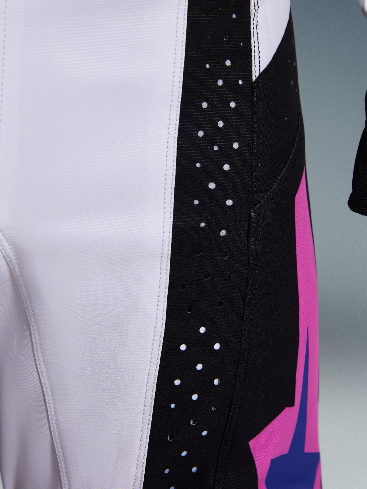 Alpinestars 2026 Techstar Knif-broek, motorcrossbroek, zwart, lichtgrijs en paars, close-up detail van lasergesneden perforaties op het zwarte zijpaneel voor ventilatie, duurzame ripstop-stofconstructie
