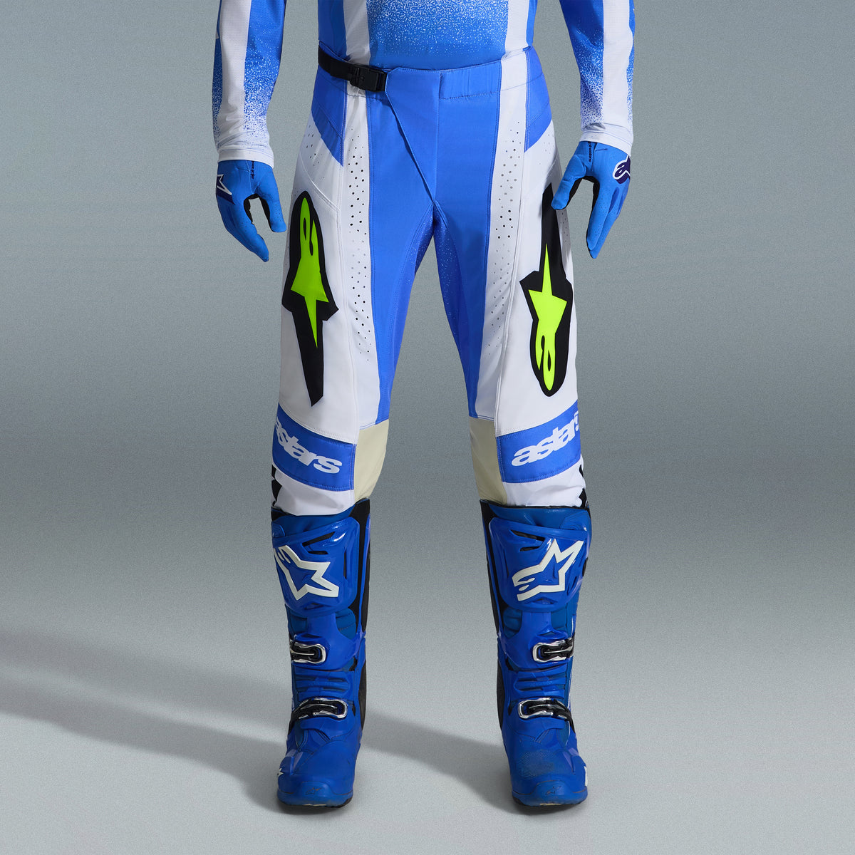 Alpinestars 2026 Techstar Knif gearset, blauw-witte motorcrossbroek met fluorescerend gele logo's, bijpassende blauwe laarzen en handschoenen, professionele sportieve race-outfit voor off-road competitie