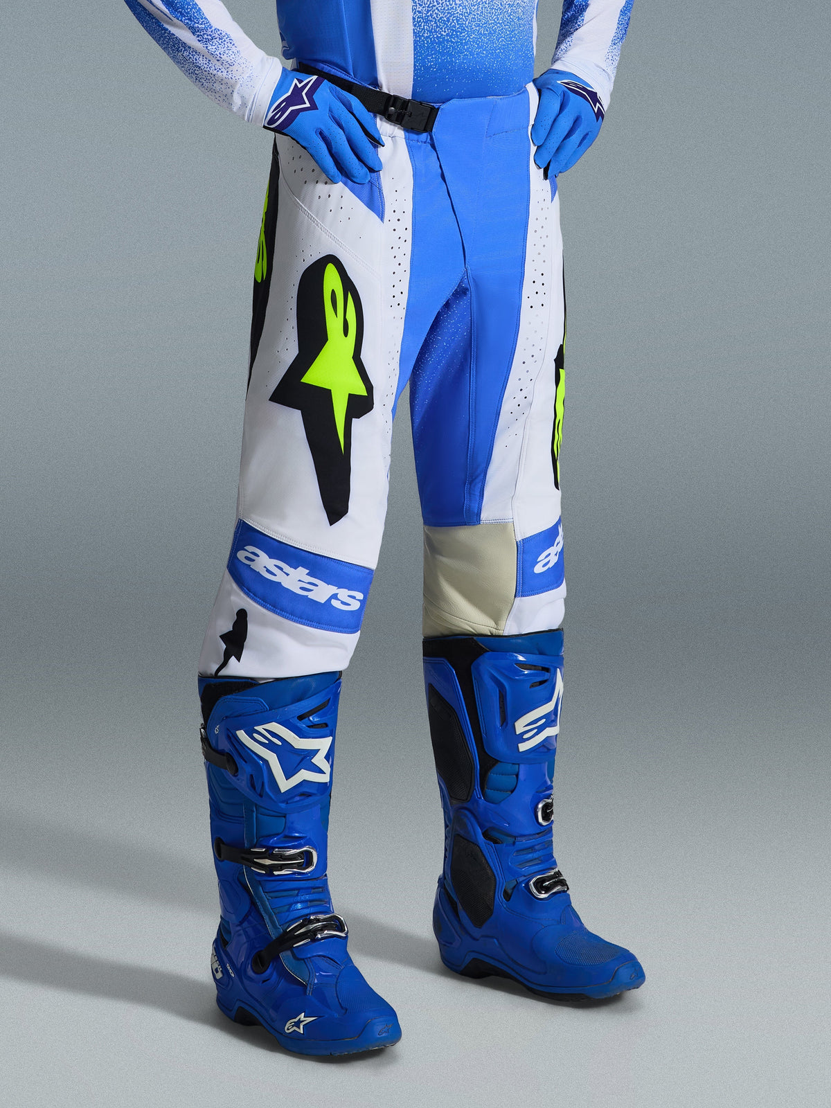 Alpinestars 2026 Techstar Knif broek, motorcross broek, UCLA blauw, wit en zwart met fluogeel, gedragen met bijpassende blauwe laarzen en handschoenen, voorzien van opvallende Alpinestars-branding en Astar-logo's, hoogwaardige uitrusting voor off-road racen.