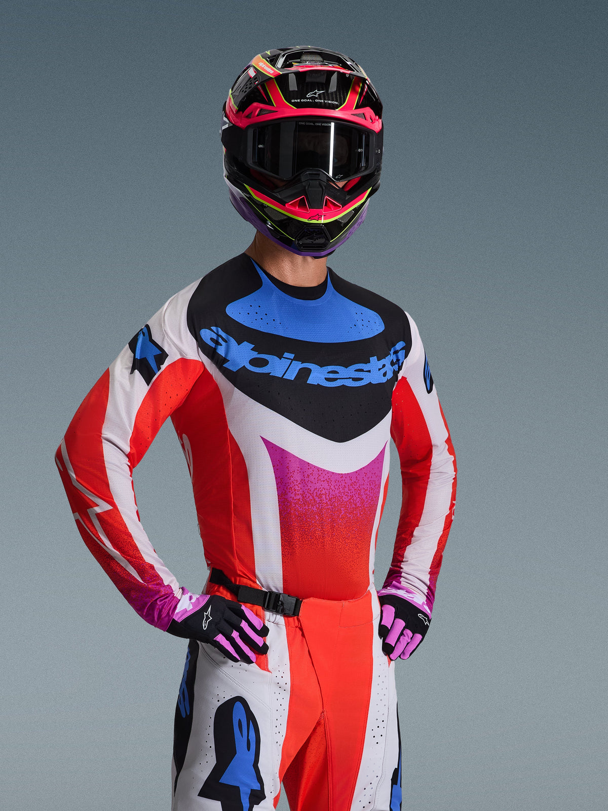 Alpinestars 2026 Techstar Knif gearset, motorcross racekleding, wit en rood shirt met roze kleurverloop en blauwe accenten, bijpassende witte en rode broek, roze en zwarte helm met donkere bril, zwarte en roze handschoenen, gecoördineerde outfit voor off-road prestaties