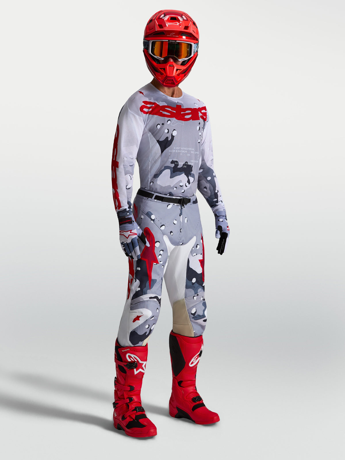 Alpinestars Racer Air Lone broek en gearset, heren motocrossoutfit in grijs camo en rood met jersey en rode motorlaarzen.