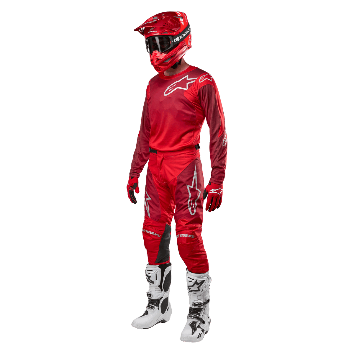 Motorcrosser in volledige race-uitrusting, Alpinestars 2024 Racer Hoen broek en jersey in Mars Red Burgundy, rode helm, rode handschoenen en witte en zwarte laarzen, gecoördineerde outfit voor off-road rijden