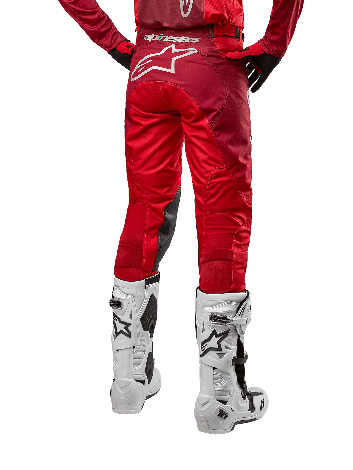 Alpinestars 2024 Racer Hoen broek, motorcrossbroek, Mars Red Burgundy, achteraanzicht met een groot wit Astar-logo op de achterzijde, zwarte kniepanelen aan de binnenzijde, gedragen met witte motorcrosslaarzen, hoogwaardige off-road uitrusting