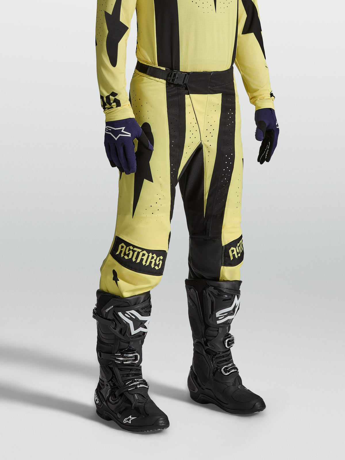 Alpinestars Techstar Atrox broek, heren motorcrossbroek in geel en zwart, duurzame 4-weg stretch ripstop, gedragen door een model met zwarte motorlaarzen en bijpassende jersey.