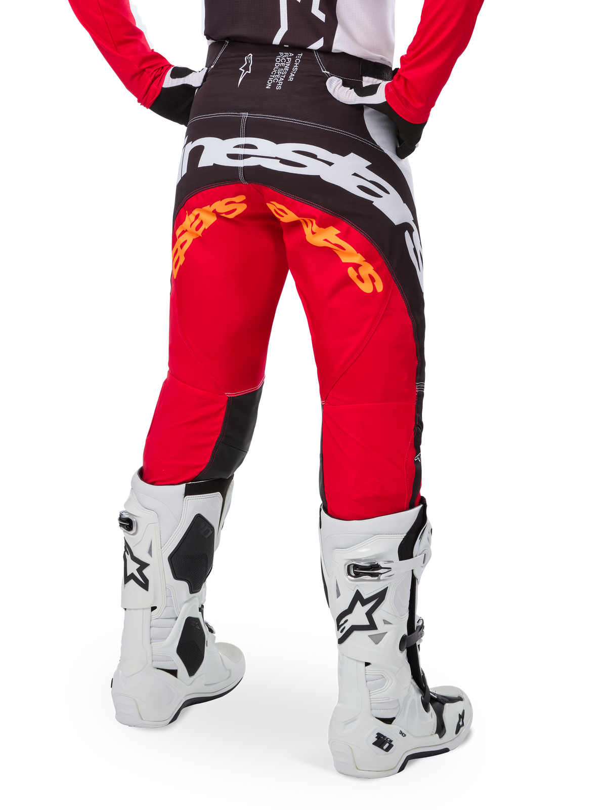 Alpinestars Limited Edition Techstar Deep crossbroek, motorcross broek, zwart, wit en felrood, achteraanzicht met opvallend wit Alpinestars-logo op het zitvlak en oranje branding, gedragen met witte technische laarzen voor professionele off-road racing