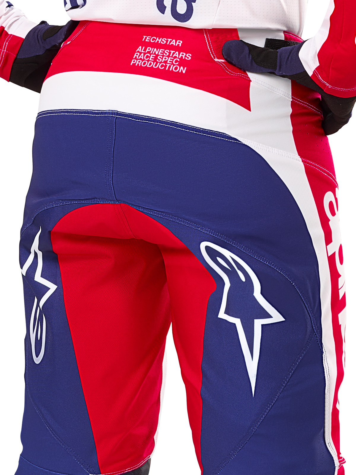 Alpinestars Limited Edition Techstar Fortitude broek, motorcrossbroek, rood, wit en blauw, achteraanzicht met grote witte sterlogo's op het zitvlak en Techstar Race Spec-branding, duurzaam hoogwaardig textiel voor off-road racen