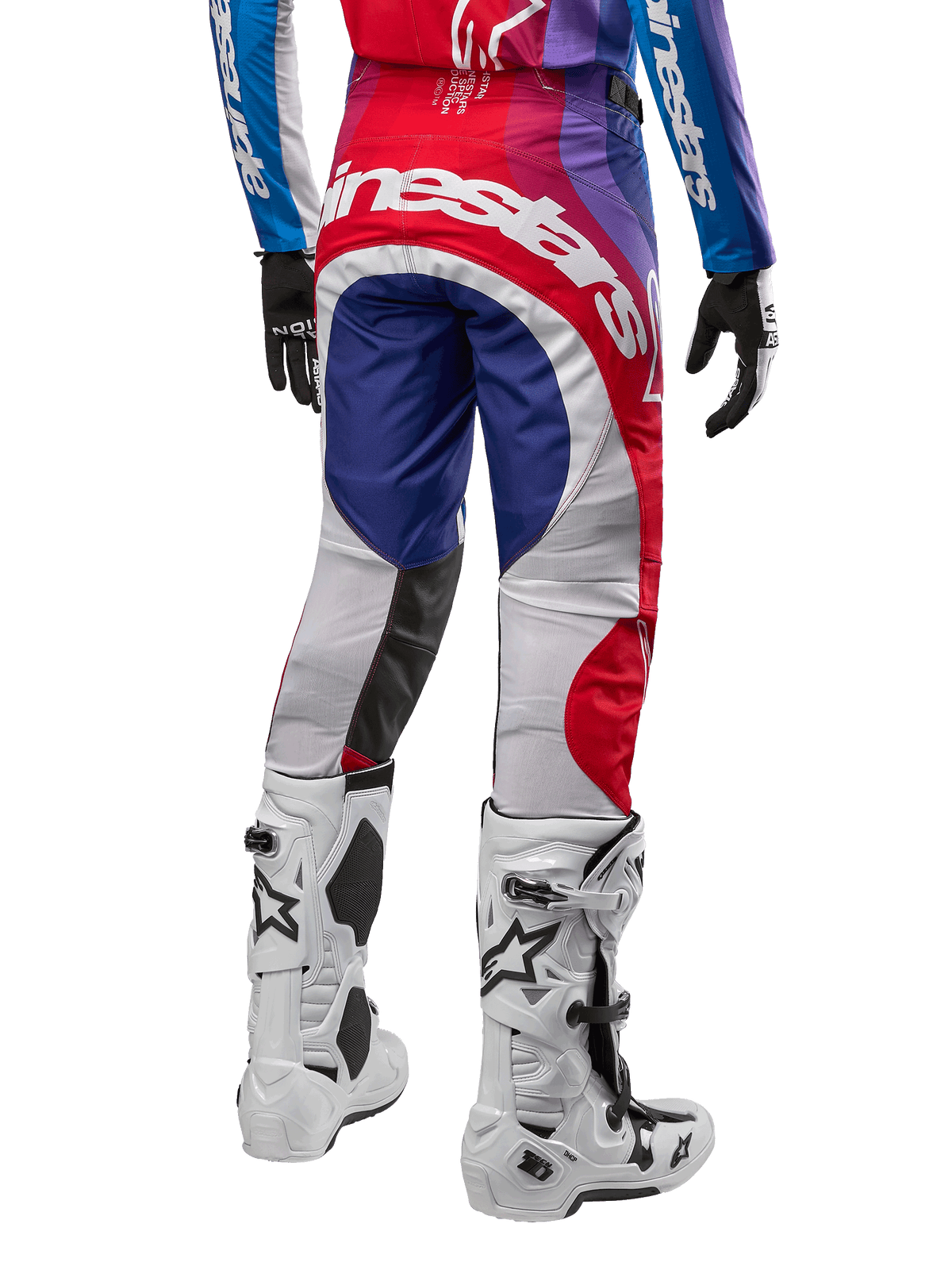 Alpinestars 2024 Techstar Pneuma crossbroek, motorcrossbroek, blauw mars rood wit, achteraanzicht gedragen met bijpassende jersey en witte laarzen, met opvallende witte branding op het zitvlak en veelkleurige panelen, professionele motorcross racekleding