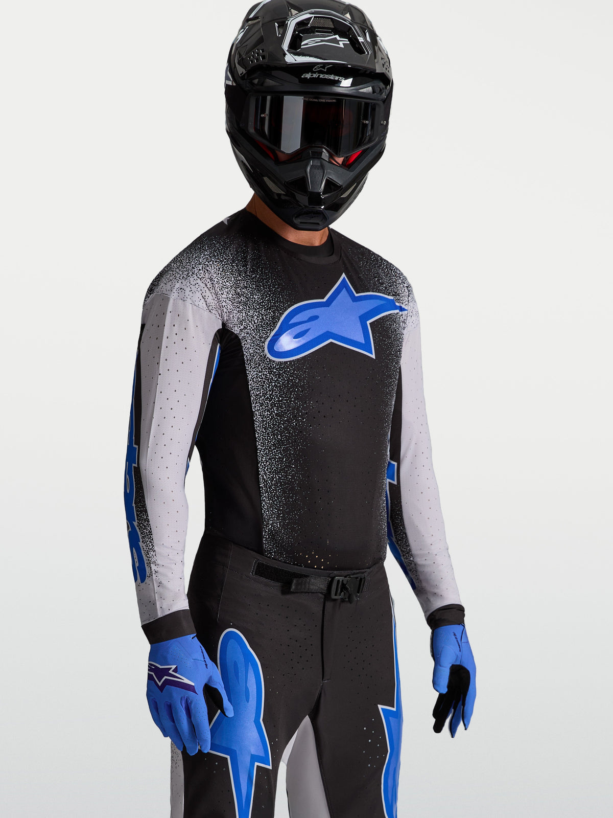 Alpinestars Supertech Hiten AFD Jersey, herenmotorcrossjersey in zwart en blauw, voorzien van AFD-schoudertechnologie en stretch mesh, gedragen door een rijder voor professionele off-road racing.