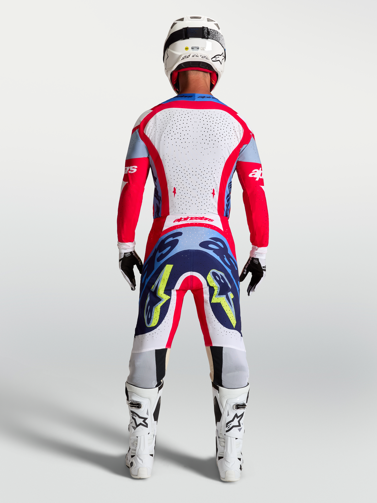Alpinestars Supertech Dyna jersey en 2027 Supertech Dyna gearset, heren-motorcrossoutfit in rood en wit, achteraanzicht.