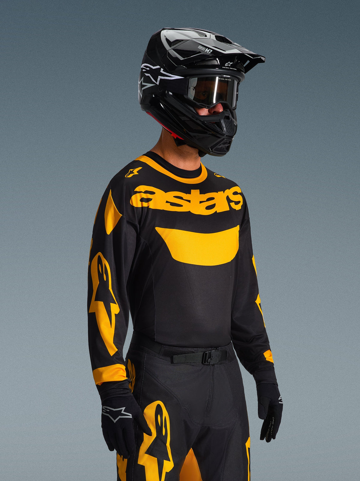 2026 Racer Riway Gear Set, motorcrosser met zwarte jersey met geel 'astars' logo en accenten op de mouwen, bijpassende zwart-gele broek, zwarte helm met crossbril en zwarte handschoenen, gecoördineerde off-road race-outfit