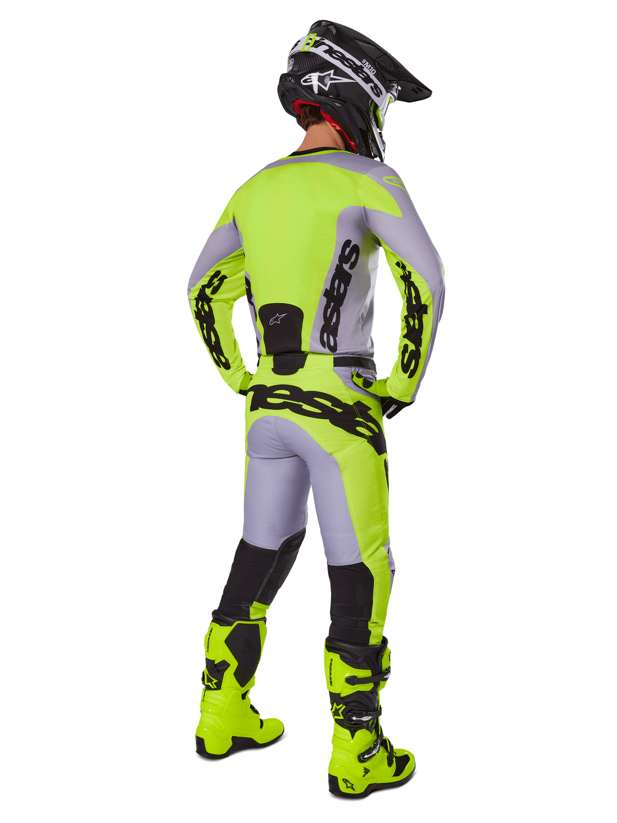 Motocrossrijder van achteren in Alpinestars 2025 Racer Veil Gear Set, grijs en fluorgeel jersey en broek, bijpassende fluorgele laarzen en zwart-gele helm, gecoördineerde outfit voor off-road racing