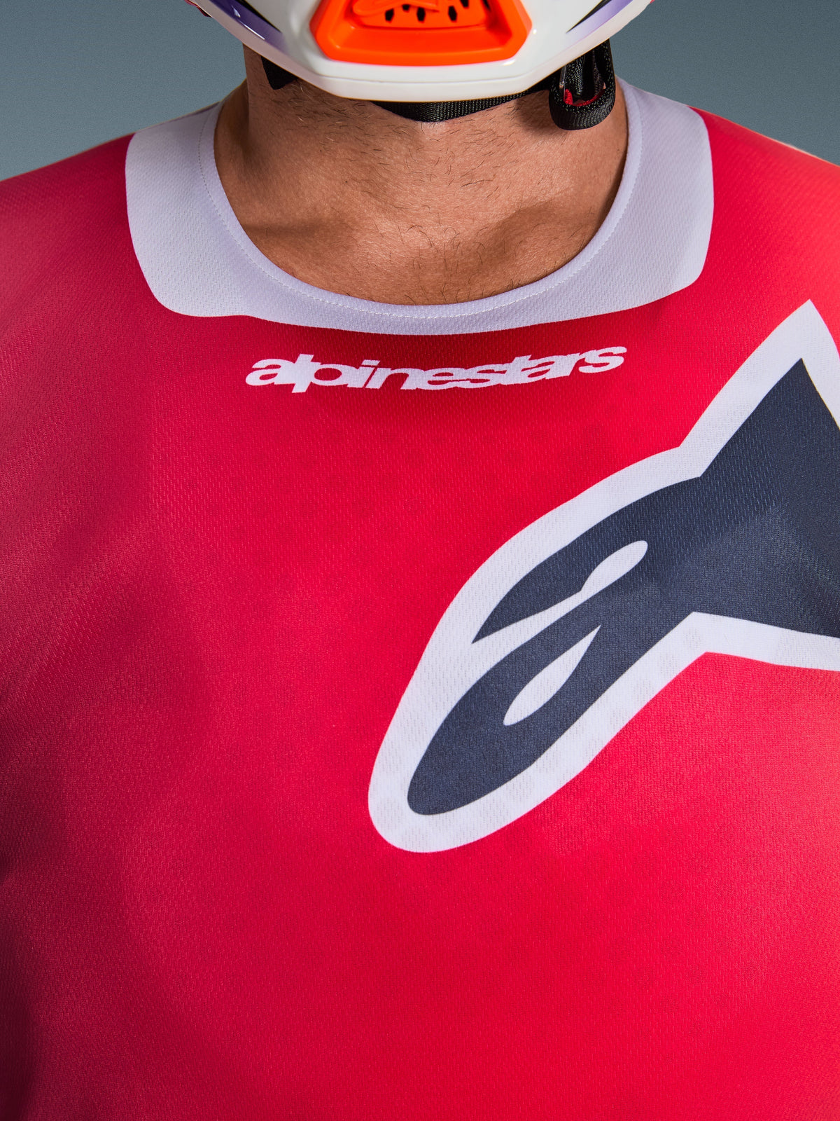 Close-up van de Alpinestars 2026 Racer Portl Jersey in het rood, met een lichtgrijze stretch kraag voorzien van witte branding en een groot zwart Astars-logo op de borst, performance motorcross race-uitrusting