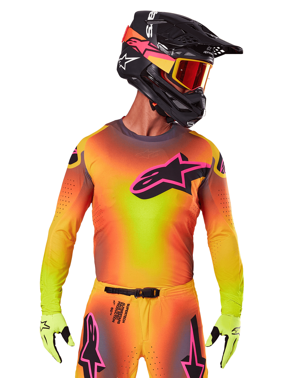 Motocrossrijder in de 2025 Supertech Lipan Jersey, levendig geel, oranje en roze kleurverloop, groot zwart Alpinestars sterlogo met roze omtrek op de borst, lasergesneden perforaties voor ventilatie, atletische racepasvorm, gecombineerd met bijpassende broek, gele handschoenen en een zwarte helm met crossbril.