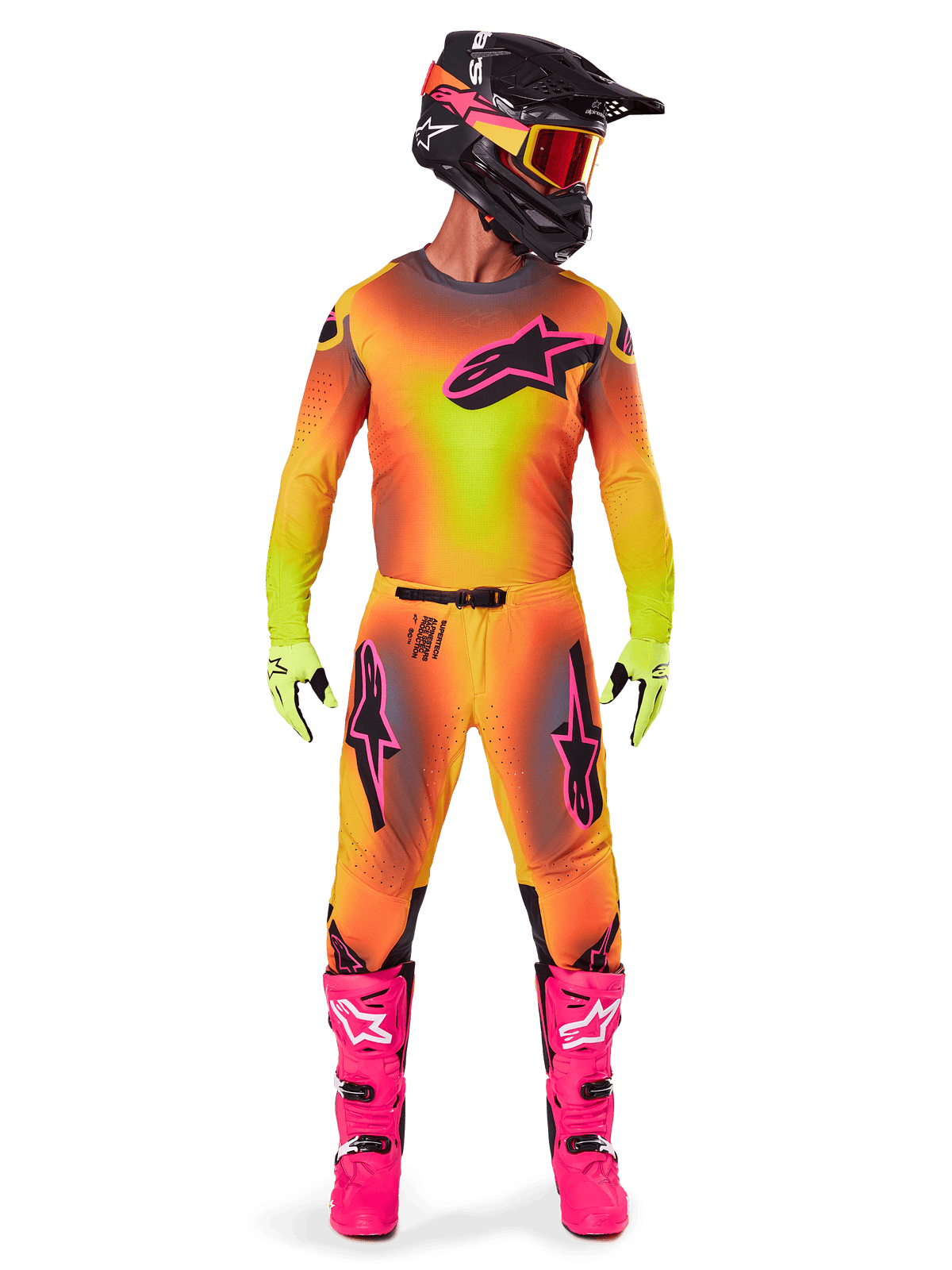 Motorcrossrijder in volledige race-uitrusting, 2025 Supertech Lipan Jersey en broek in een geel-oranje kleurverloop met roze accenten, zwarte helm met bijpassende roze graphics, felroze laarzen en limoengroene handschoenen, gecoördineerde Alpinestars off-road outfit.