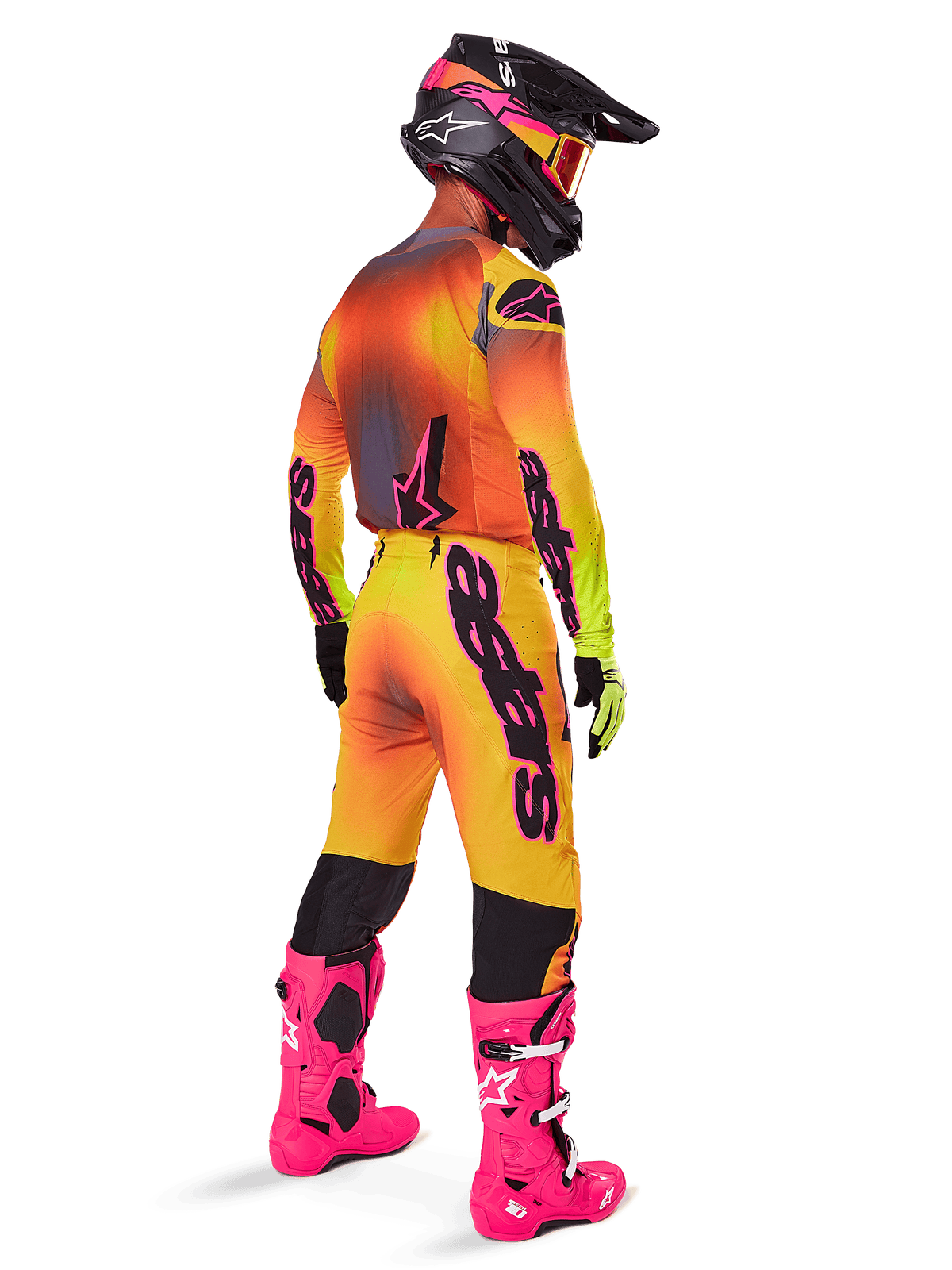 Alpinestars 2025 Supertech Lipan Gear Set, motorcrosser van achteren gezien, geel en oranje jersey met kleurverloop en roze accenten, bijpassende broek, felroze laarzen en zwarte helm met roze en gele graphics, professionele race-outfit