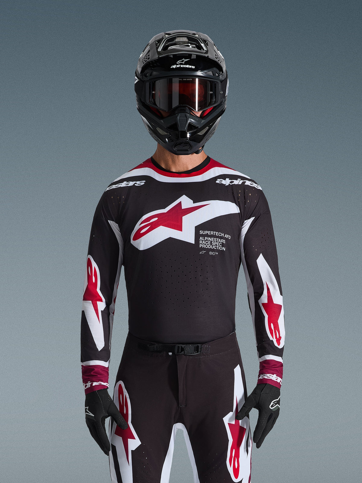 Alpinestars 2026 Supertech AFD Vista gear set, motorcross set, zwart shirt met rode en witte logo's en 'Supertech AFD' branding, bijpassende zwarte broek met rode accenten, zwarte helm met rode crossbril, gecoördineerde professionele race-outfit