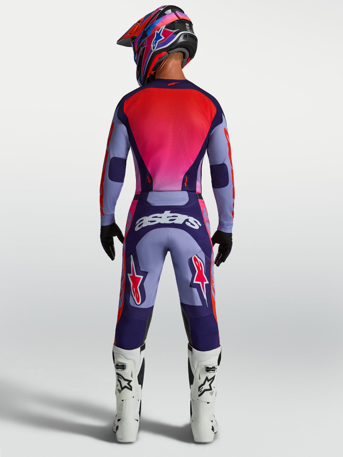 Alpinestars Racer Air Hunt uitrustingsset, paarse en rode geventileerde motocrossjersey en broek, achteraanzicht op rijder.