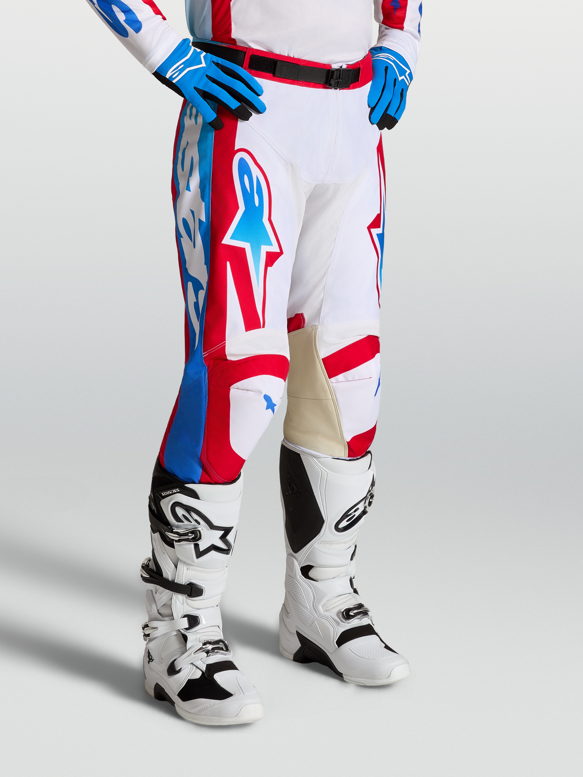 Alpinestars Racer Hunt Broek, motocrossbroek in wit, rood en blauw met voorgevormde broekspijpen en leren binnenknieën.