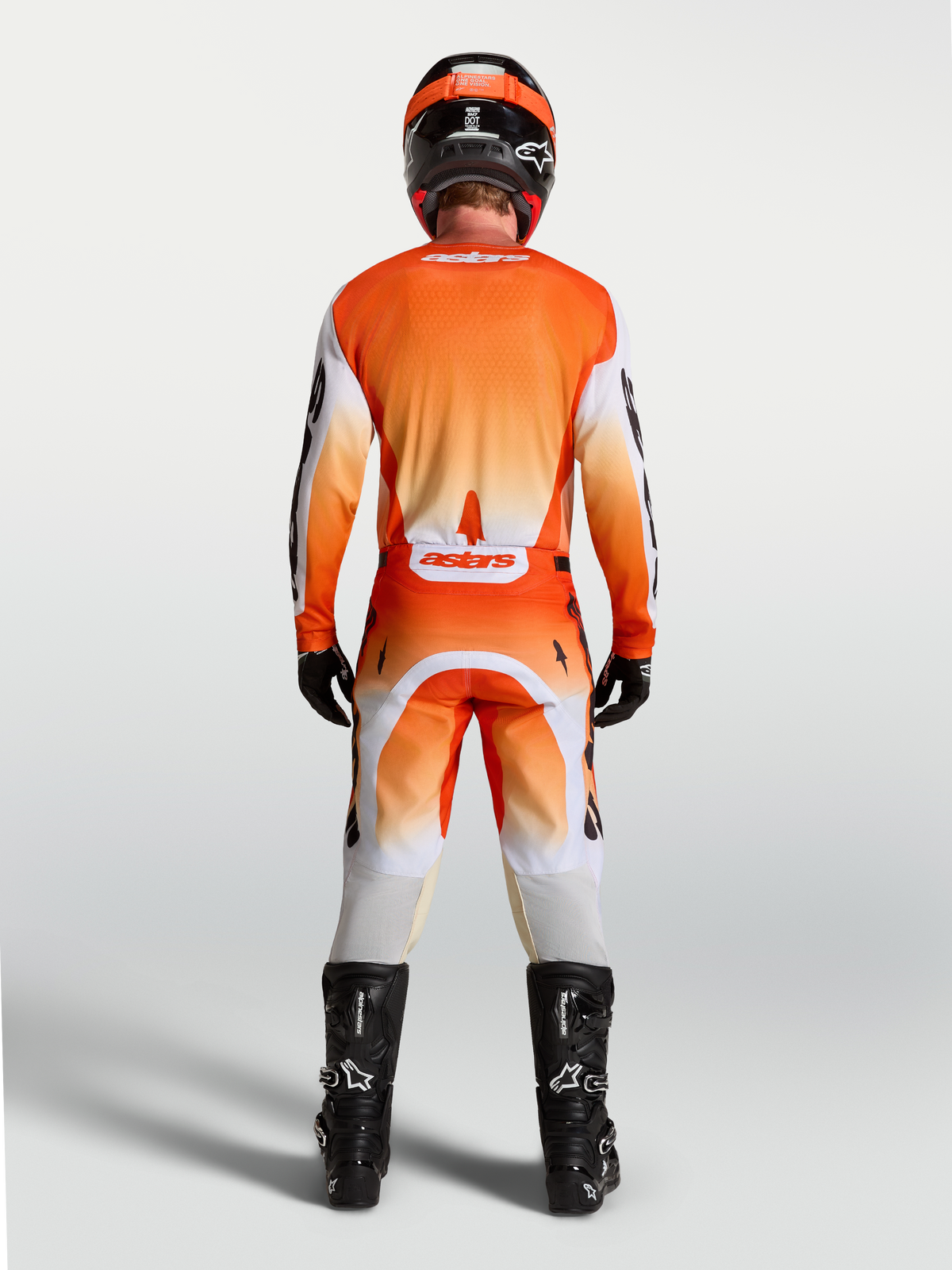 Alpinestars Racer Amber jersey, achteraanzicht op model, oranje en wit motorcrossjersey met ademende race-pasvorm.