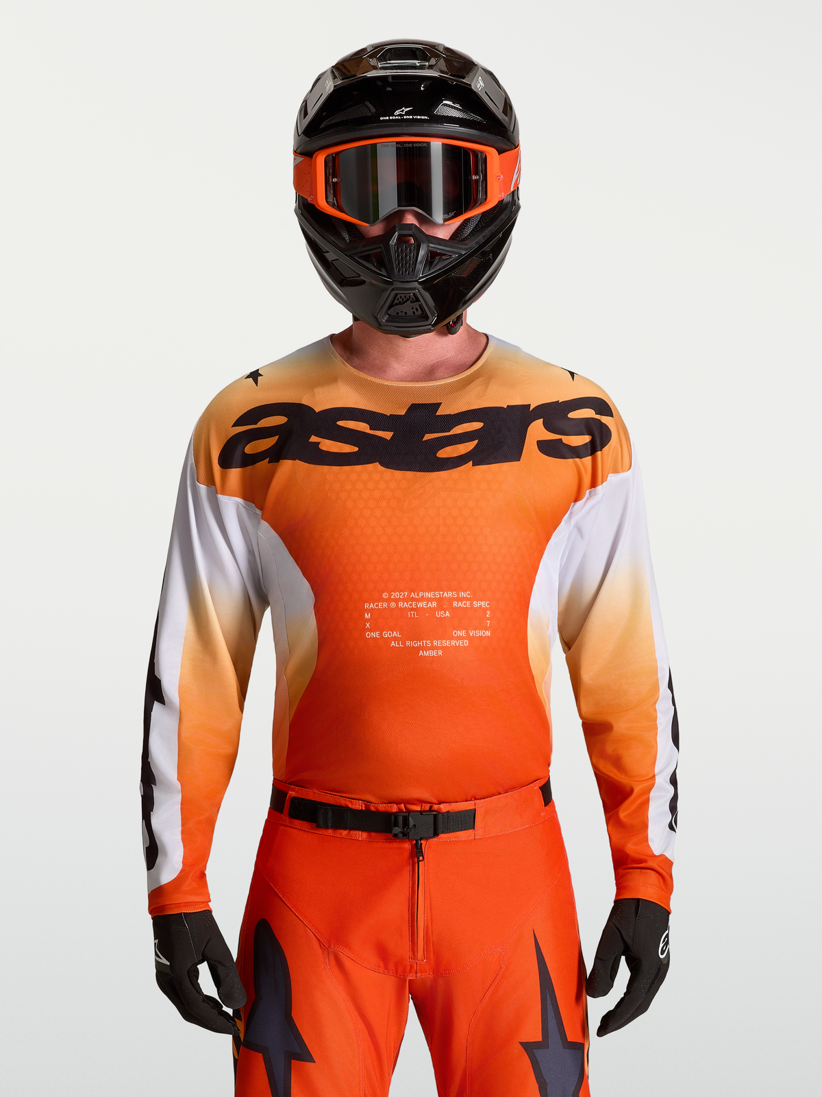 Alpinestars Racer Amber jersey, heren-motocrossjersey in oranje en wit, vochtafdrijvend polyfabric op model, korte opstaande kraag, astars branding, MX racing gear.