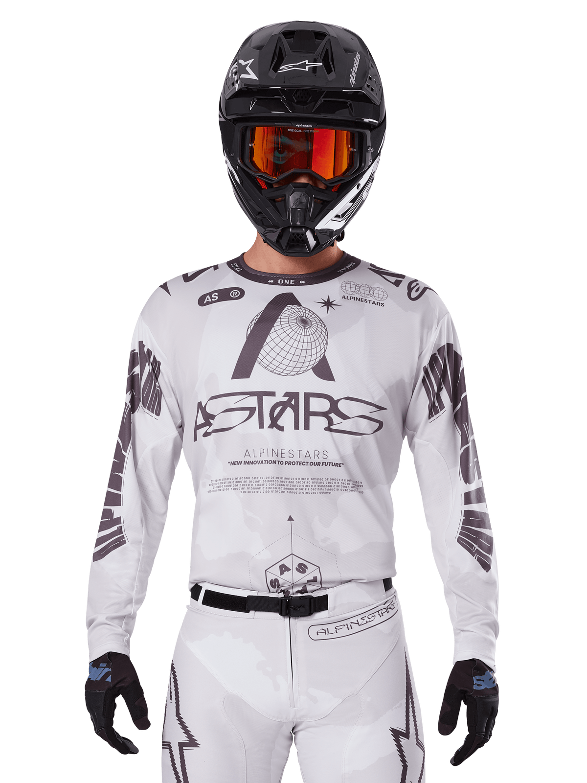 Alpinestars 2025 Racer Hollow Jersey, motocross jersey, wit en zwart, gedragen met een bijpassende witte MX-broek en een zwarte helm met oranje crossbril, voorzien van opvallende Alpinestars-branding en wereldbol-graphics, professionele off-road race-uitrusting