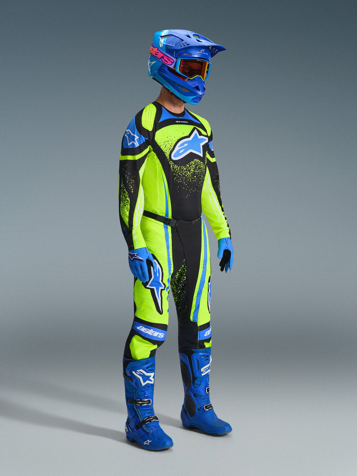 Motocross rider wearing complete racing gear, 2026 Techstar Nomur Jersey in Dark Navy and Yellow Fluo, matching pants, blue helmet with goggles, blue boots and gloves, coordinated outfit for off-road racing