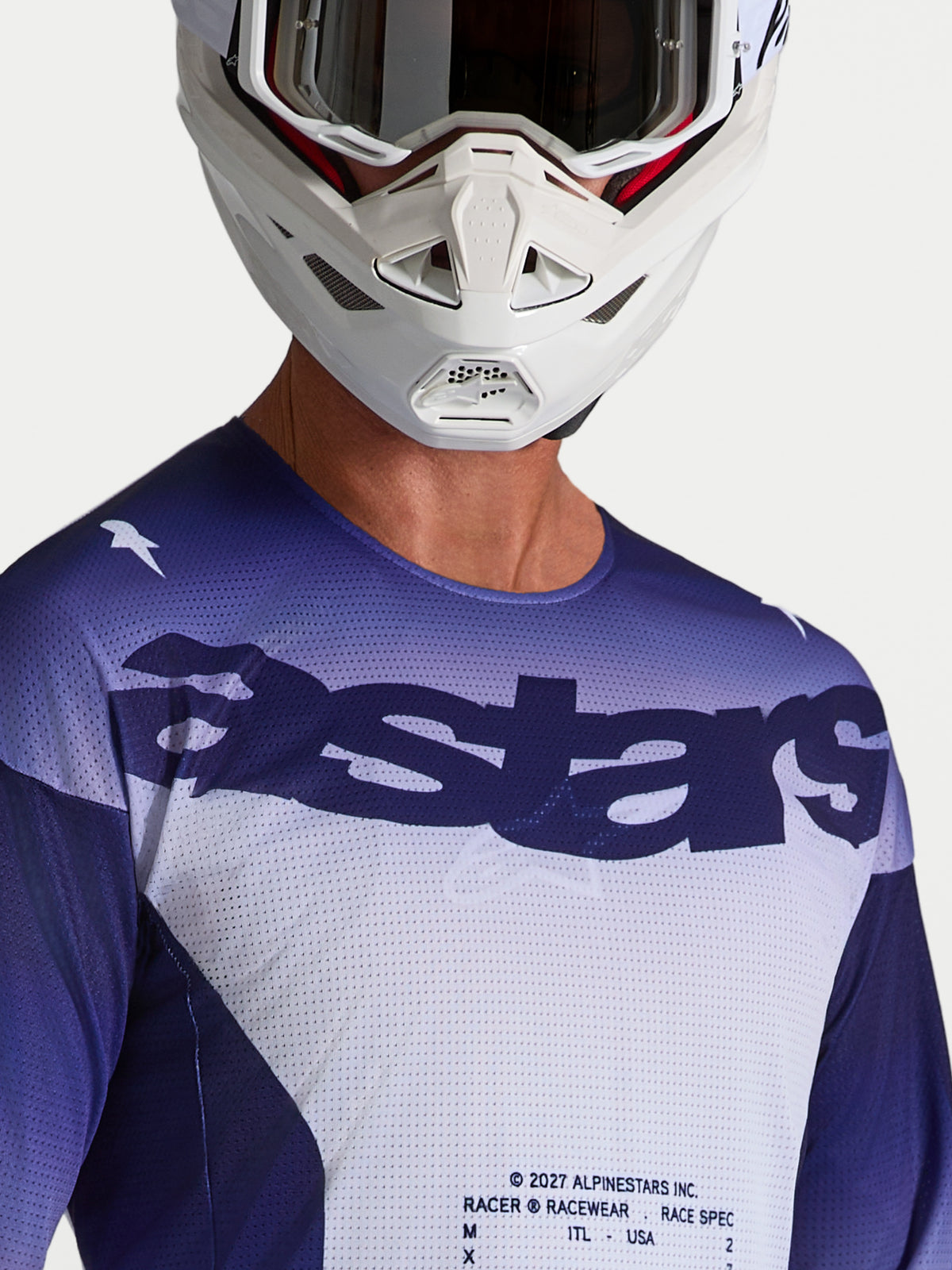 Alpinestars Racer Air Amber Jersey, motocrossjersey voor heren, blauw en wit, meshconstructie met astars-logo, gedragen door model met witte motorcrosshelm.