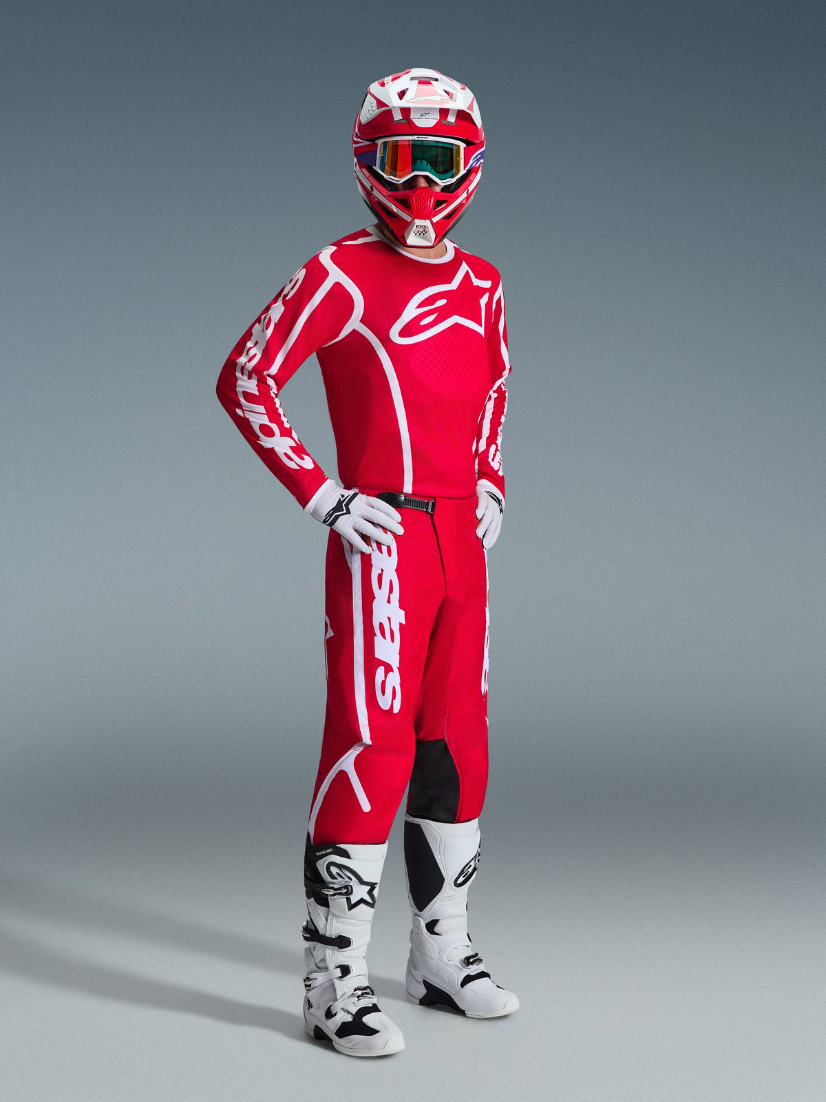 Motorcrosser die de Alpinestars 2026 Fluid Apex Gear Set draagt, rode jersey met grote witte logo's, bijpassende rode broek met witte branding, witte en rode helm, witte motorcrosslaarzen en handschoenen, gecoördineerde outfit voor off-road racing