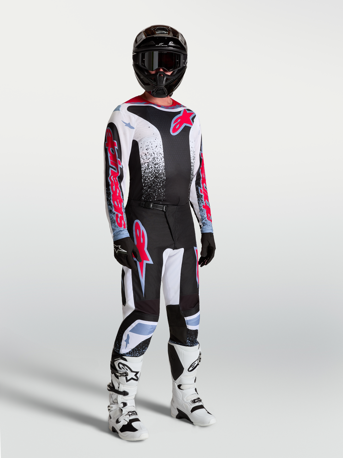 Alpinestars Fluid Drag jersey, ademende heren-motocrossjersey in zwart, wit en fluo rood, gedragen op model met volledige off-road uitrusting.