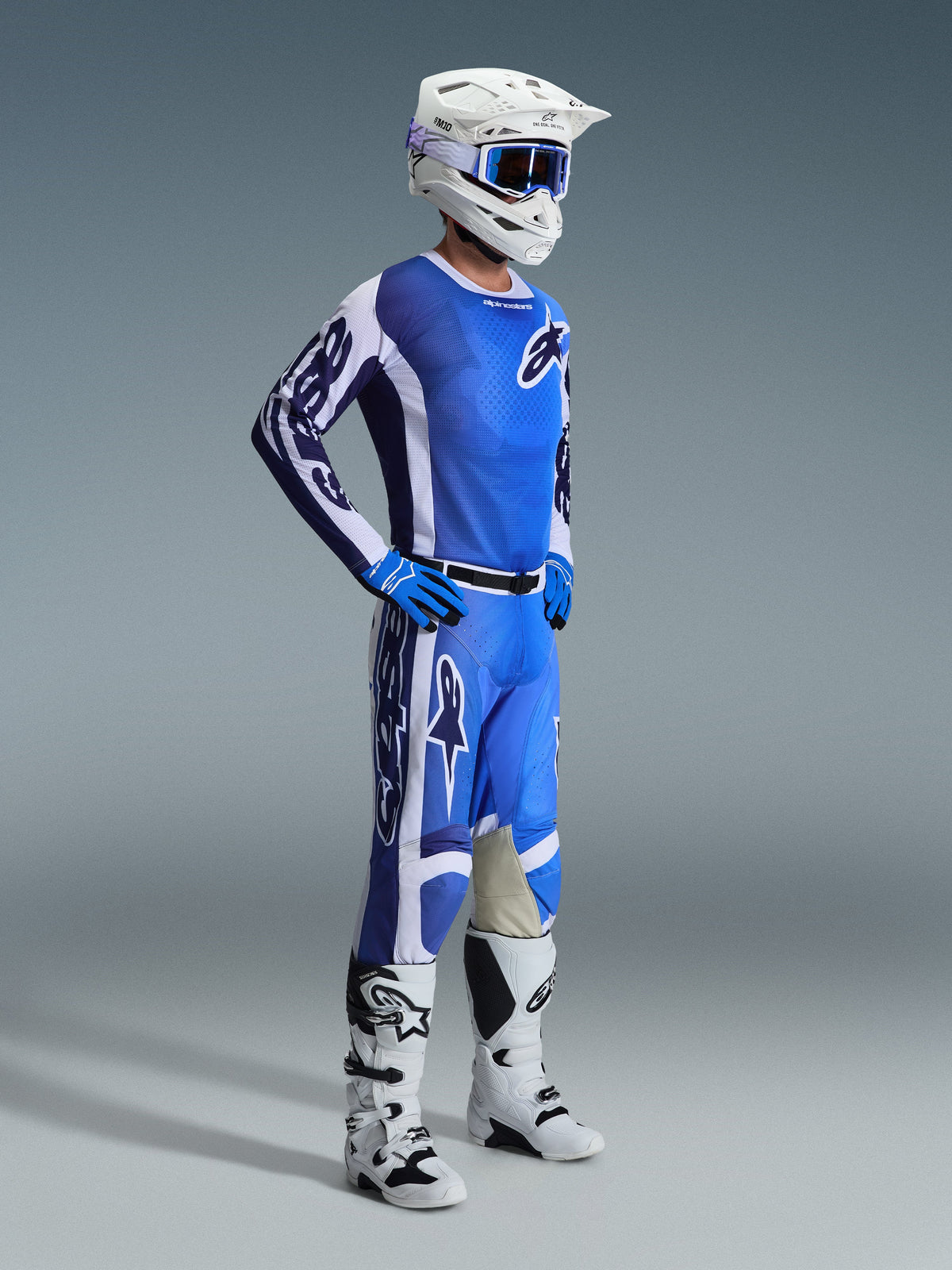 Alpinestars 2026 Racer Air Portl Jersey, motorcrosser in volledige off-road race-uitrusting, Ucla Blue en wit, met bijpassende blauwe en witte broek, witte helm, blauwe crossbril en witte en zwarte laarzen
