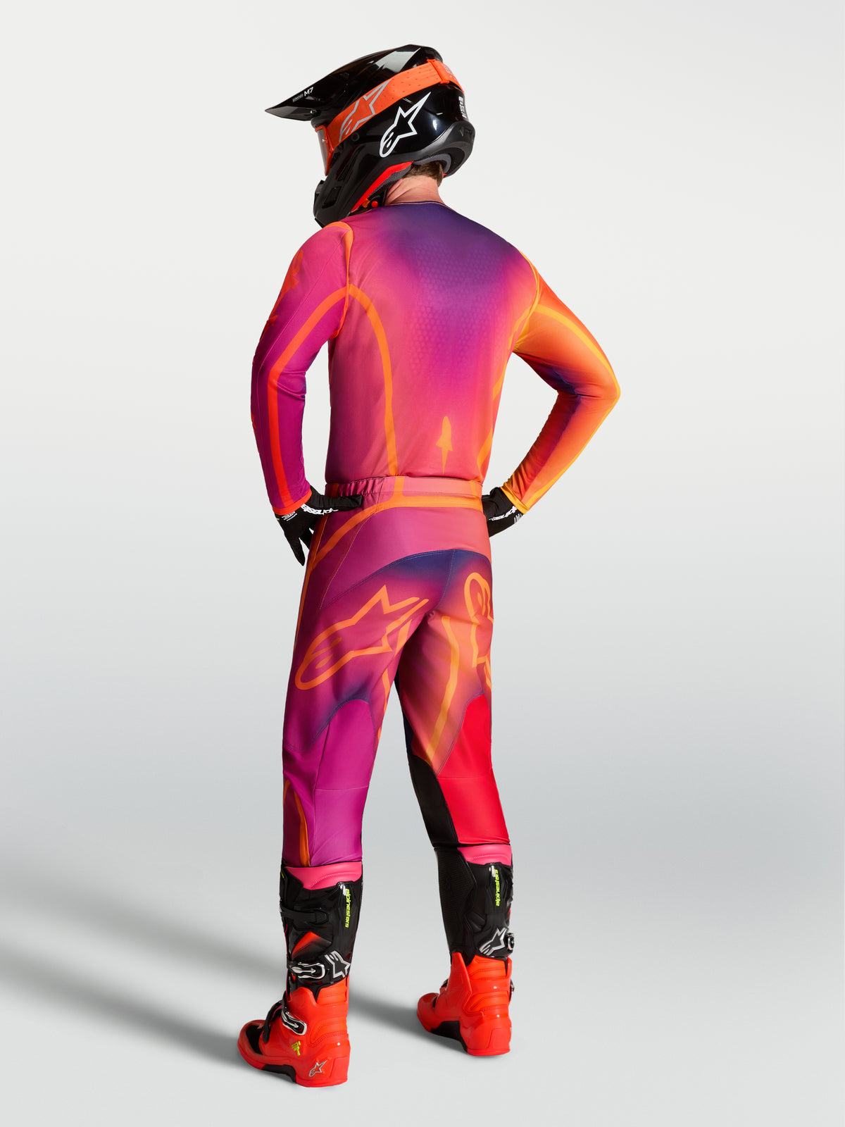 Alpinestars Fluid Kepler jersey, motocrossuitrusting voor heren, paars en oranje, achteraanzicht op een rijder.
