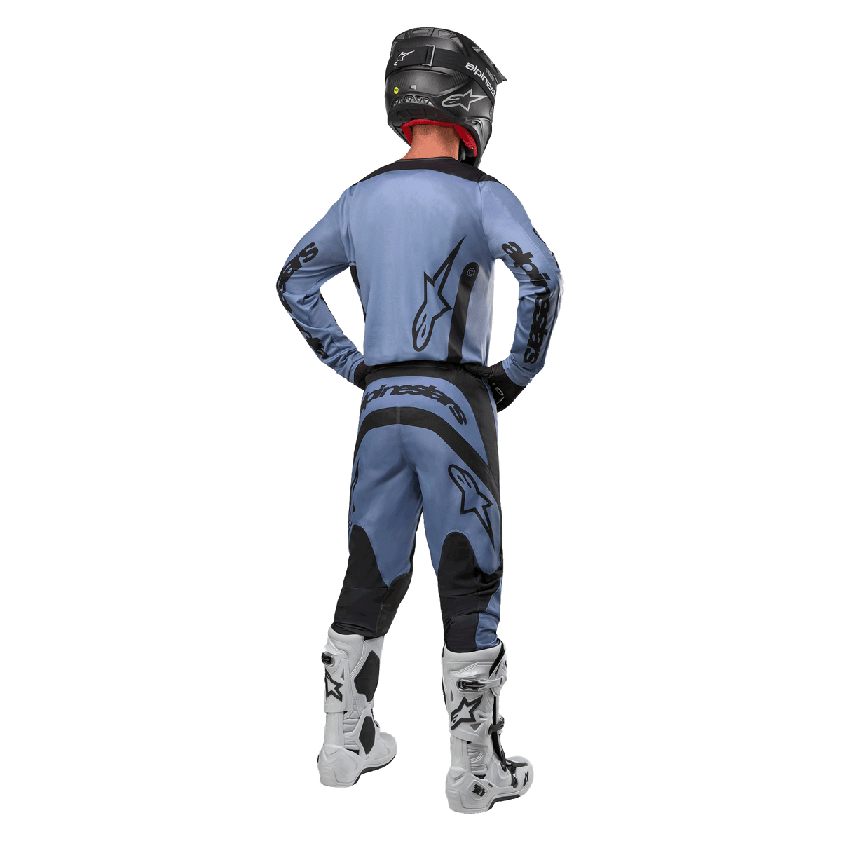 Alpinestars 2024 Fluid Lurv Jersey en bijpassende broek in lichtblauw en zwart, motorcrosser van achteren gezien, met zwarte logo's op de rug en mouwen, gecombineerd met een zwarte helm en witte laarzen