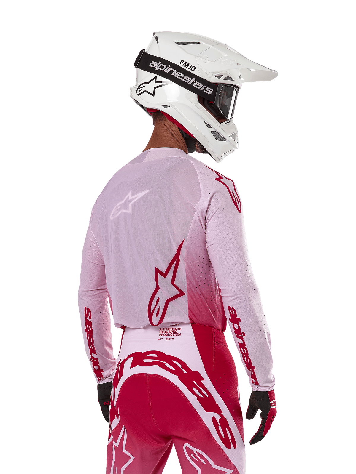 Alpinestars 2024 Supertech Dade Jersey in Red Berry Lilac, motorcrosser van achteren gezien, ademende mesh-panelen en rode Alpinestars-logo's, gecombineerd met een bijpassende rode en lila broek en een witte Alpinestars-helm met crossbril, professionele off-road race-uitrusting.