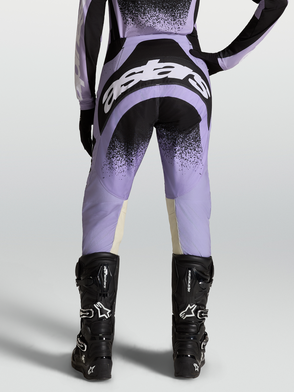 Alpinestars Stella Techstar Swan Broek, dames motorcrossbroek, paars en zwart, met zwarte motorlaarzen.