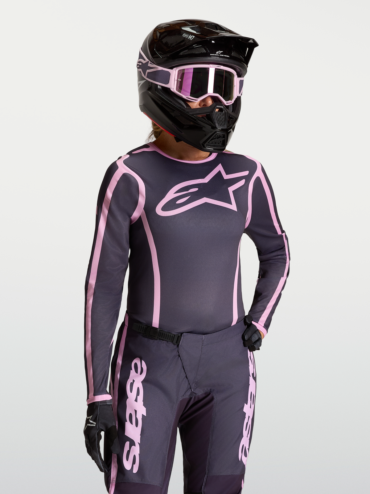 Alpinestars Stella Fluid Apex V2 jersey, dames motorcrossjersey in grijs en roze, lichtgewicht en ergonomische uitrusting gedragen door een model.