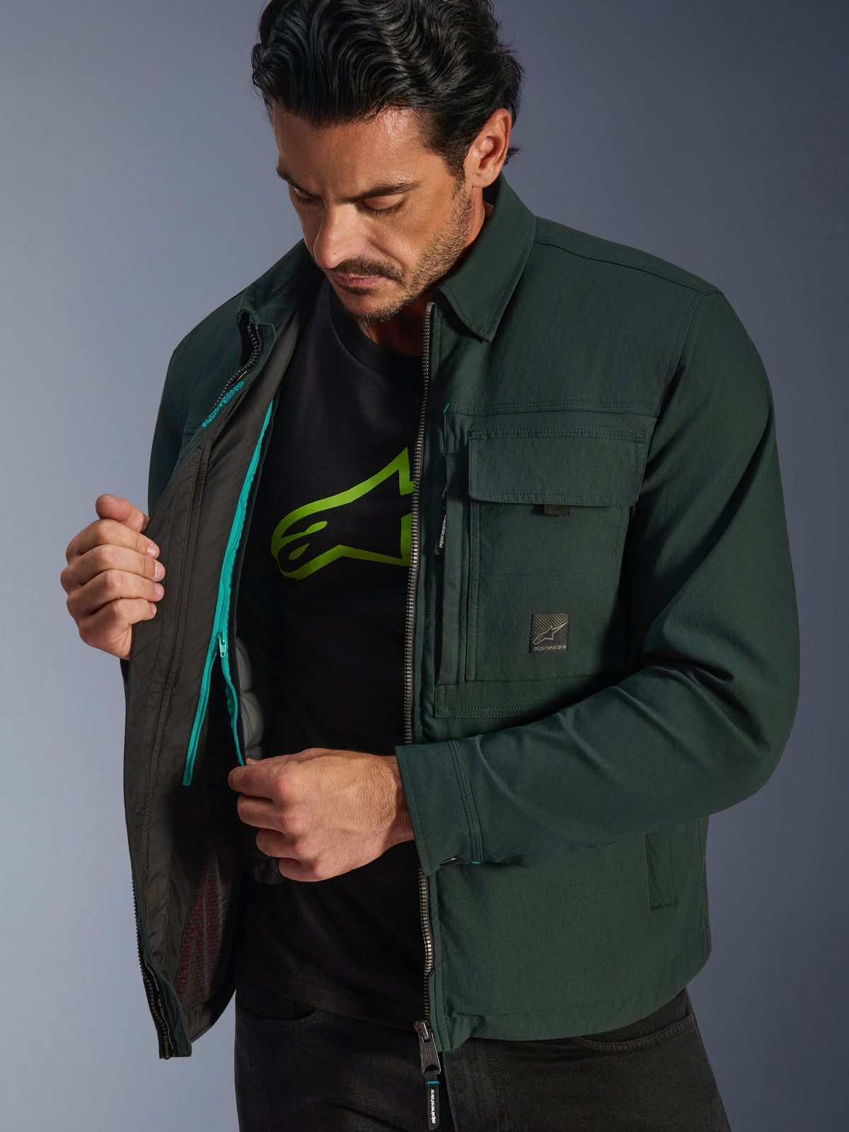 Alpinestars Bryon Water Resistant Overshirt, Dark Emerald, lifestyle view of model revealing the interior thermal vest and teal zipper detail, urban motorcycle jacket with waxed canvas and cargo pockets