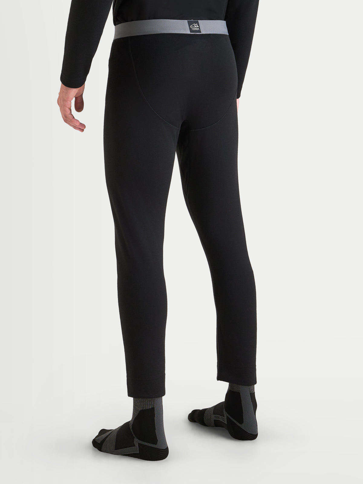 Alpinestars At 8 Merino Bottom basislaag, thermische motor-basislaag voor heren in zwart, achteraanzicht op model met elastische tailleband en merinowol