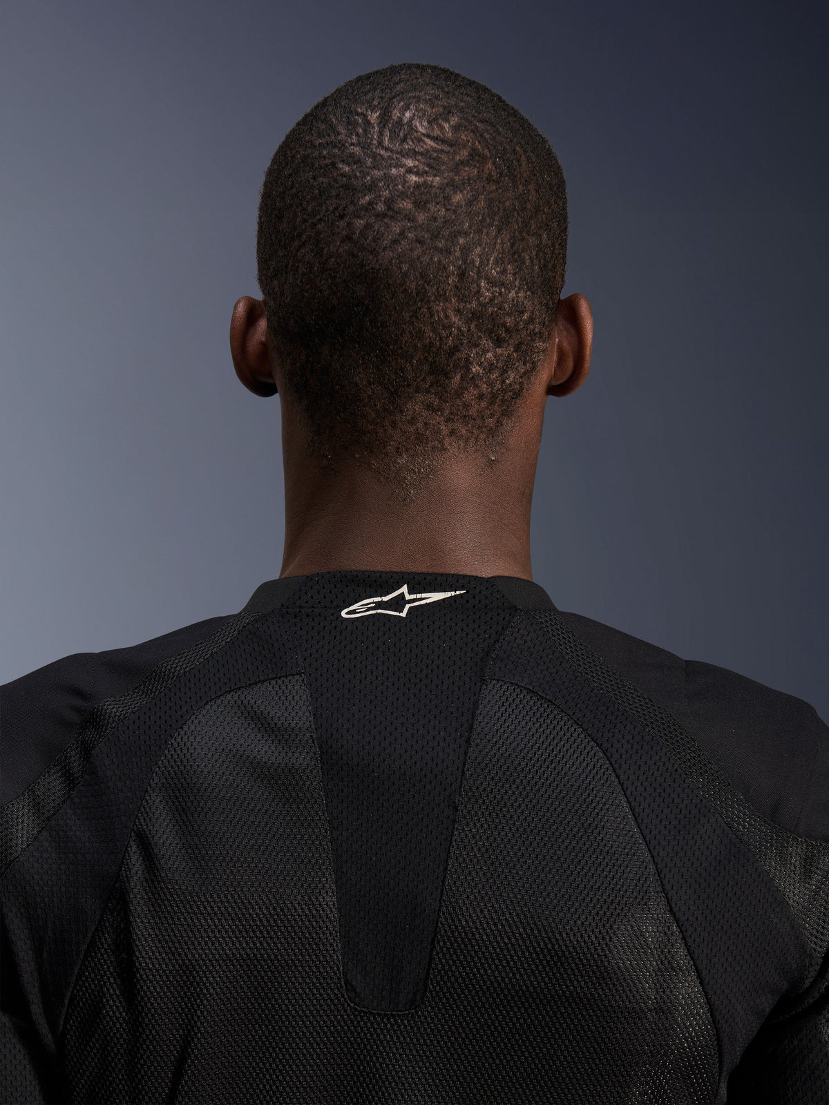 Alpinestars Troop-Air jas, detail van zwarte technische mesh herenmotorjas met wit logo op de achterzijde van de nek.