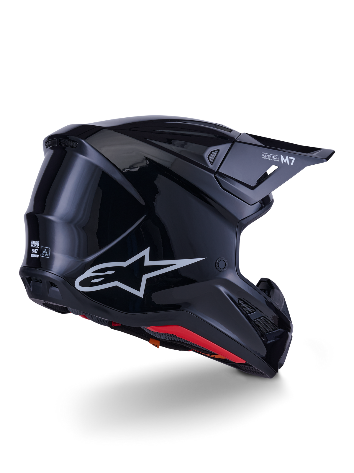 Alpinestars S-M7 Solid helm, motorcrosshelm, glanzend zwart, voorzien van een slanke aerodynamische schaal met een zilveren Astars-logo, rode binnenafwerking en geïntegreerde ventilatieopeningen, ontworpen voor off-road racebescherming