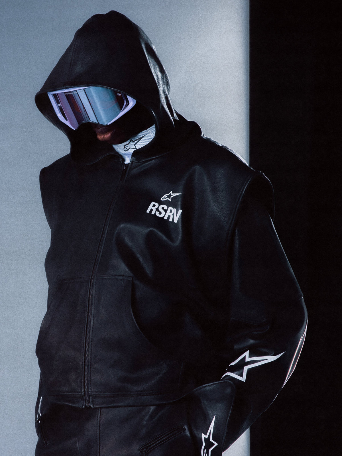Alpinestars RSRV Axis leren hoodie, zwart, premium leer, futuristisch design met reflecterende details, RSRV-logo en sterren op mouwen, capuchon met rits