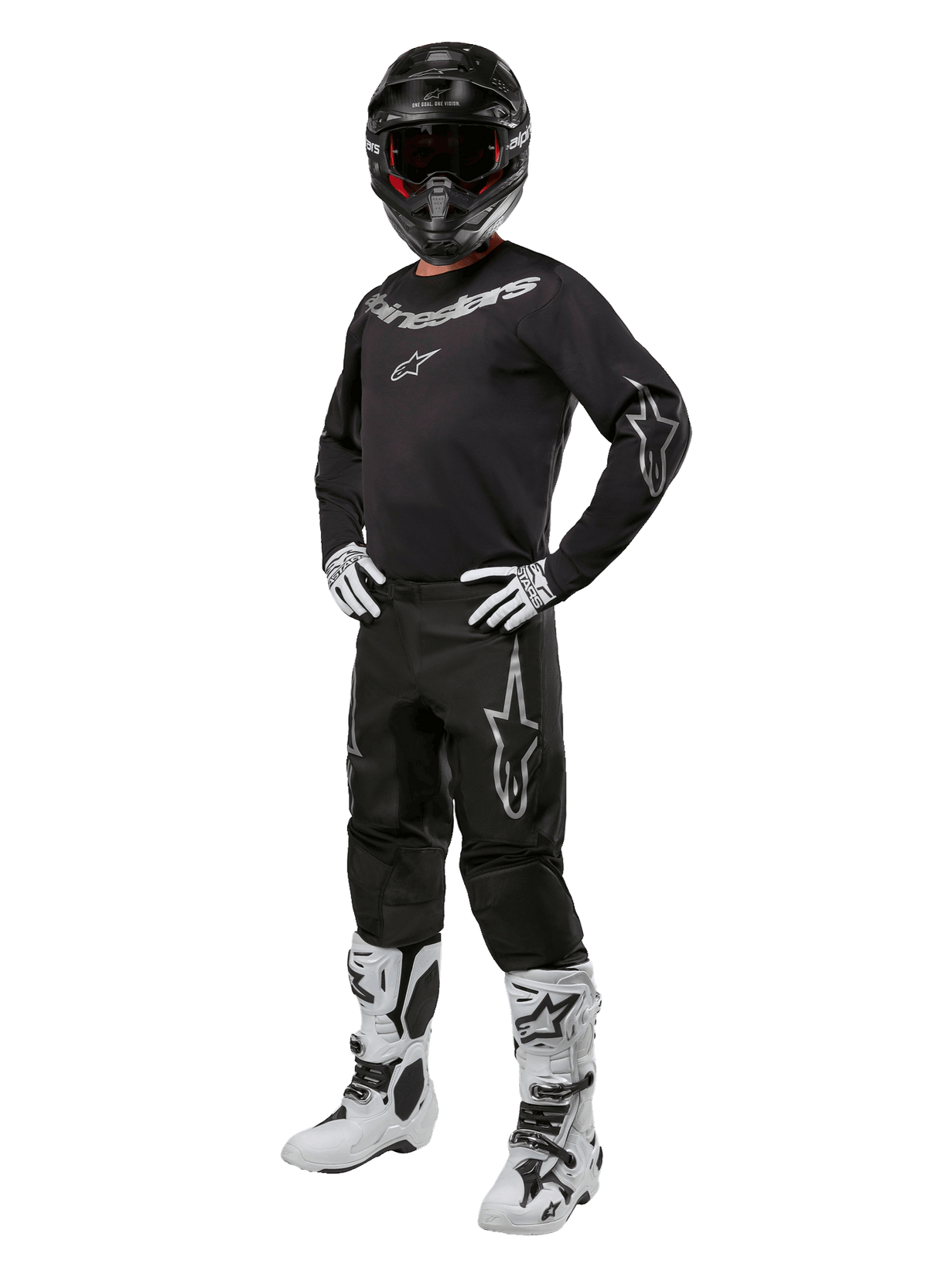 Alpinestars 2024 Fluid Graphite Gear Set, complete motorcross outfit, zwart met grijze en witte logo's, inclusief jersey en broek gedragen met bijpassende zwarte helm, witte en zwarte handschoenen en laarzen, ontworpen voor off-road bescherming