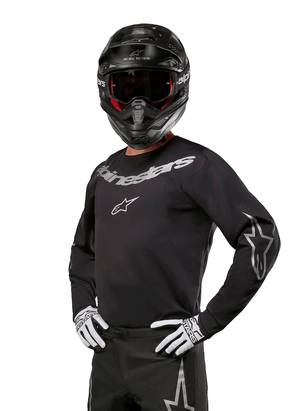 Alpinestars 2024 Fluid Graphite kledingset, motorcrossrijder in zwart en grijs jersey met opvallende grijze logo's, bijpassende broek, zwarte helm en wit/zwarte handschoenen, atletische sportpasvorm voor off-road motorcrossraces