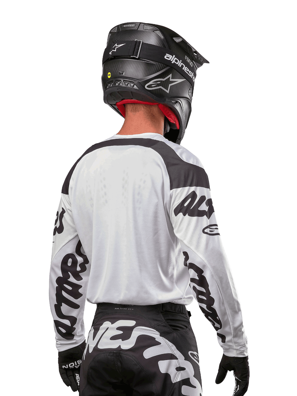 Alpinestars 2024 Racer Hana Jersey, White and Black, back view showing ergonomic fit and bold sleeve branding, paired with a black motocross helmet and matching black and white pants, high-performance racing gear for off-road riding