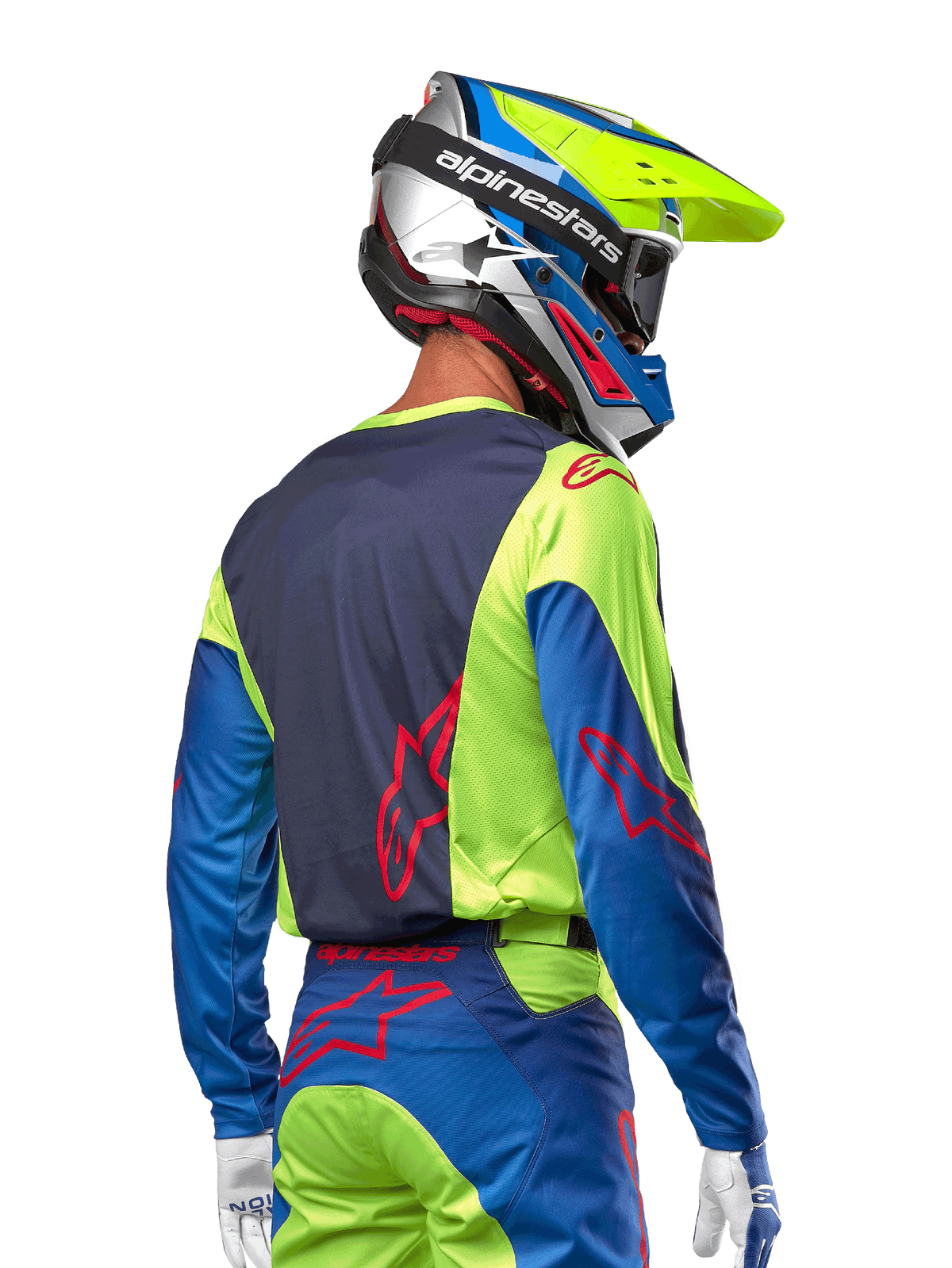 Motorcrosser in de Alpinestars 2024 Racer Hoen Jersey in Yellow Fluo en Blue Night Navy, met een rood sterlogo op de rug, bijpassende motorcrossbroek en een gecoördineerde helm, achteraanzicht dat het ergonomische ontwerp voor off-road prestaties toont.
