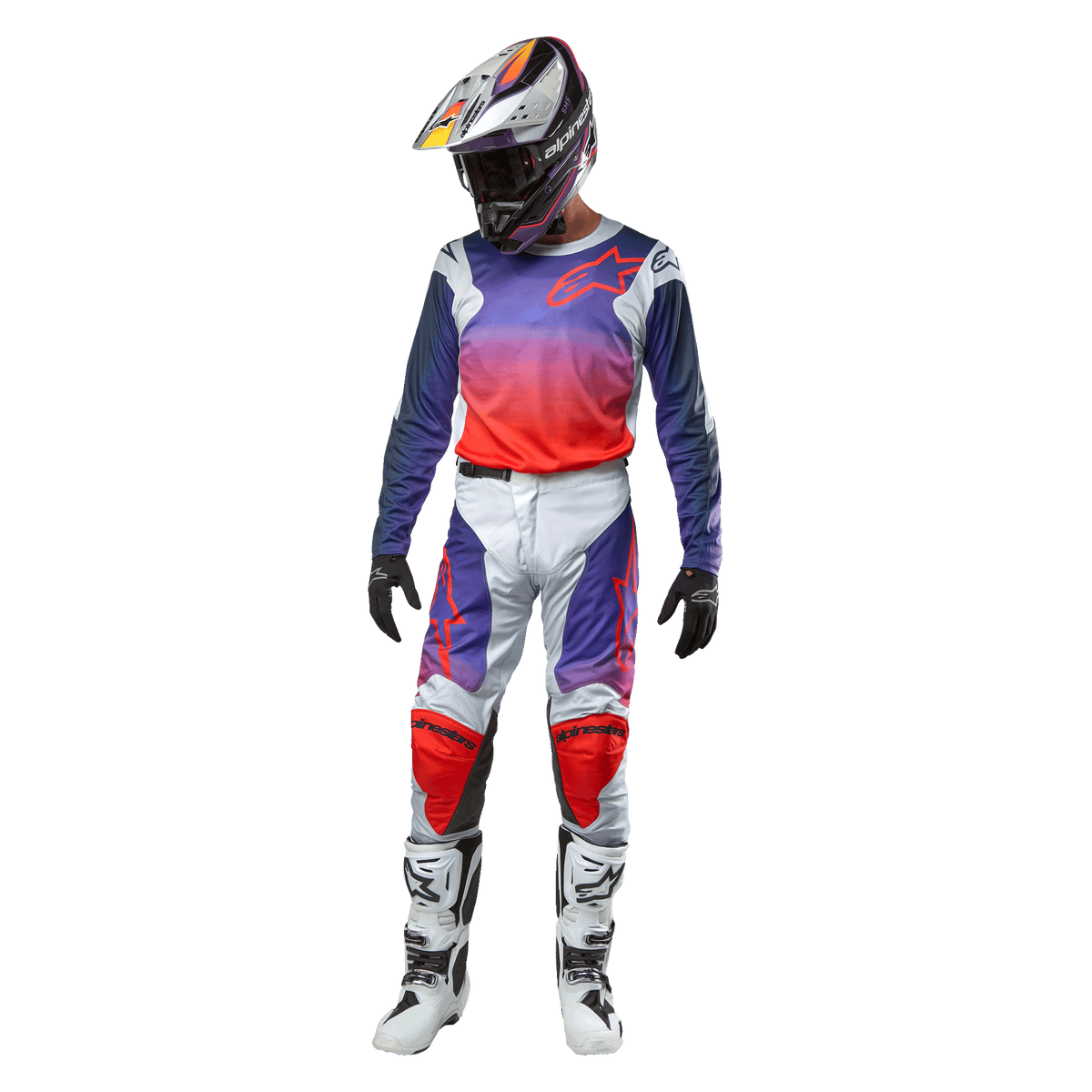 Alpinestars 2024 Racer Hoen crossbroek, motorcross broek, lichtgrijs met paars naar oranje kleurverloop en zwarte accenten, persoon draagt volledige motorcross uitrusting met bijpassende jersey, helm en laarzen.