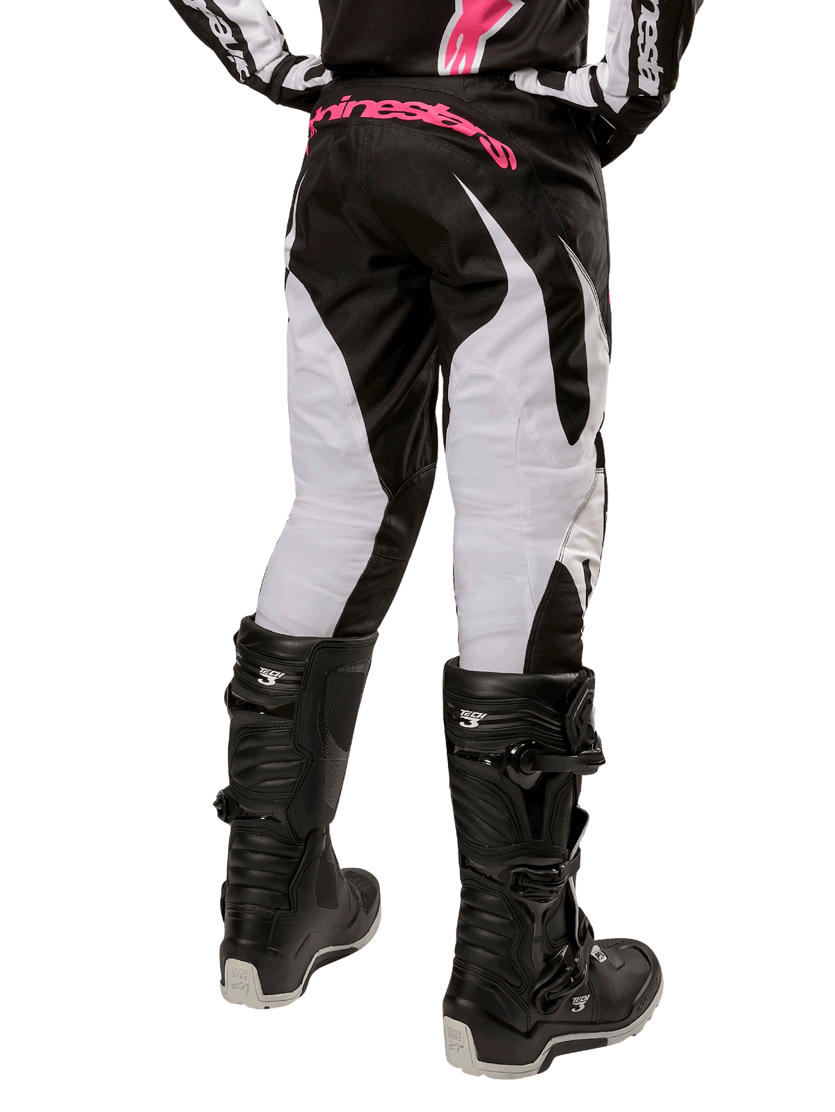 Alpinestars Stella 2024 Fluid dames motorcrossbroek, zwart en wit, achteraanzicht met witte beenpanelen en roze logo op de tailleband, gedragen met zwarte Tech 3-laarzen, duurzame uitrusting voor off-road racen