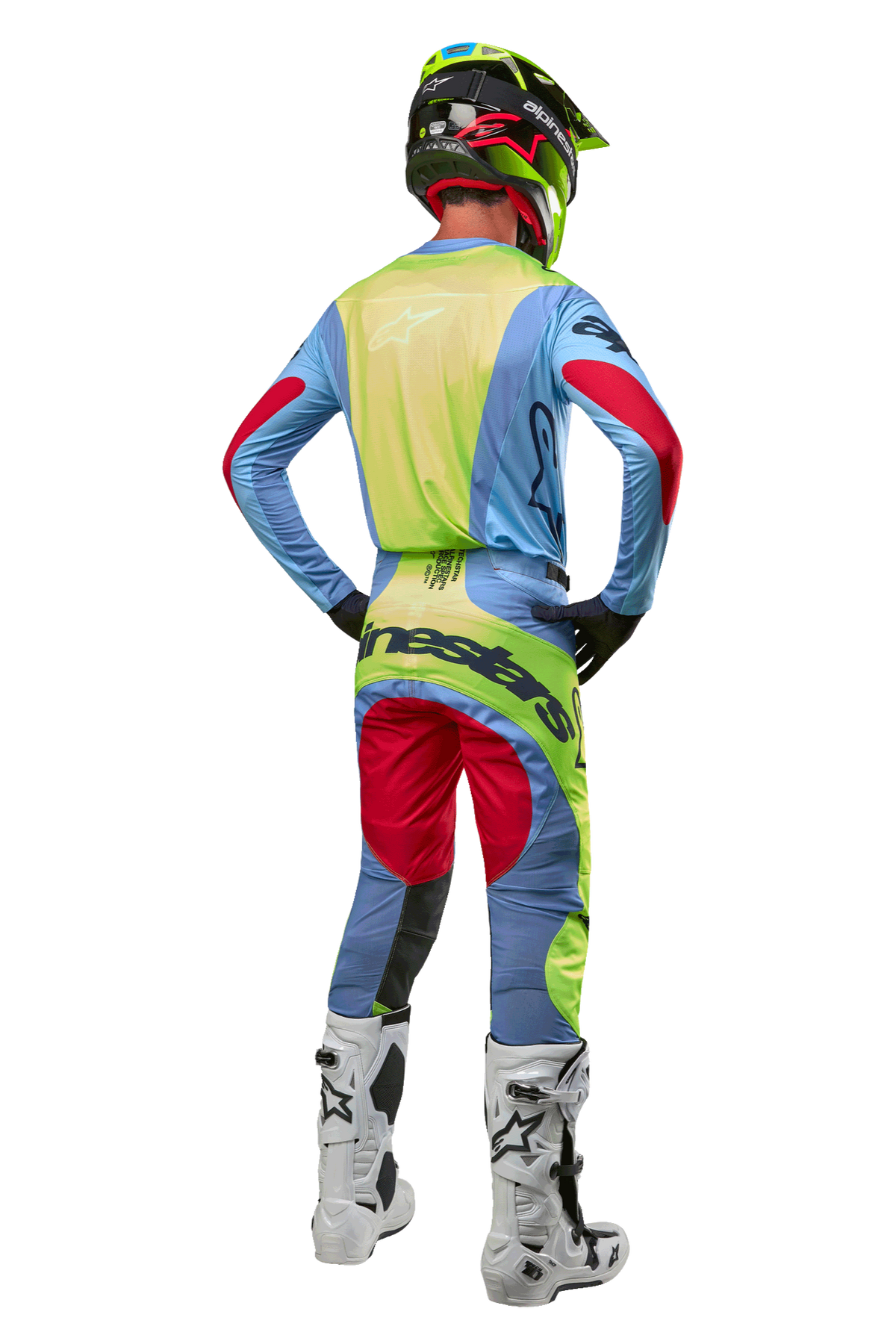 Motorcrosser van achteren gezien in 2024 Techstar Ocuri-broek en bijpassende jersey, lichtblauw, fluor geel en bessenrood, witte en zwarte laarzen, zwarte helm met neon accenten, gecoördineerde Alpinestars-uitrusting voor off-road racen